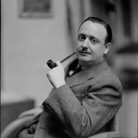 John Dickson Carr author photo. Black and white photo of man in suit jacket smoking a pipe