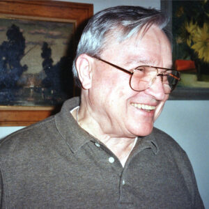 K.C. Constantine author photo. Profile shot of man with glasses and short, gray hair.