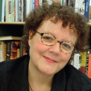 A headshot of Julia Keller in front of a bookshelf.